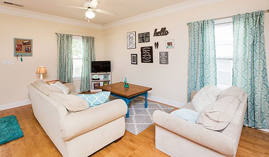Living room with two white loveseats and small TV in the corner.